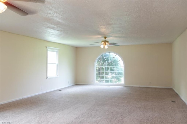 empty room with ceiling fan, carpet floors, a textured ceiling, and baseboards