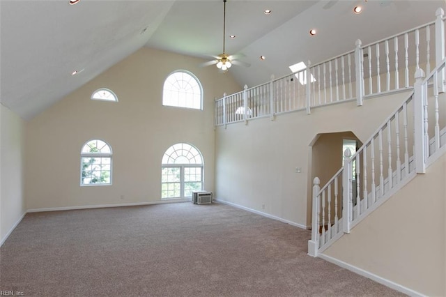 unfurnished living room featuring baseboards, a ceiling fan, stairway, carpet, and high vaulted ceiling