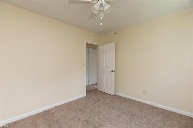 empty room featuring baseboards, a ceiling fan, and light colored carpet