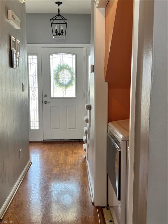 foyer featuring washer / clothes dryer, light wood-type flooring, and baseboards