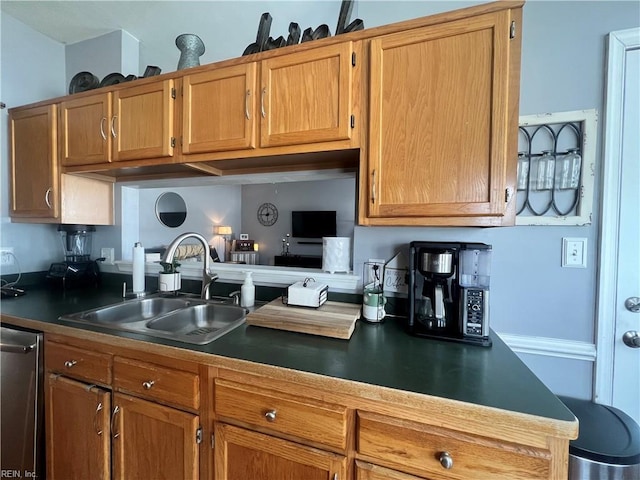 kitchen with dark countertops, dishwasher, brown cabinetry, and a sink