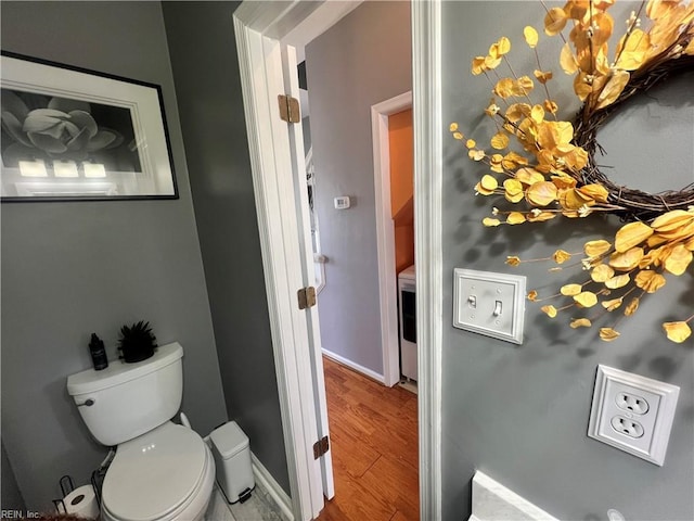 bathroom featuring toilet, baseboards, and wood finished floors