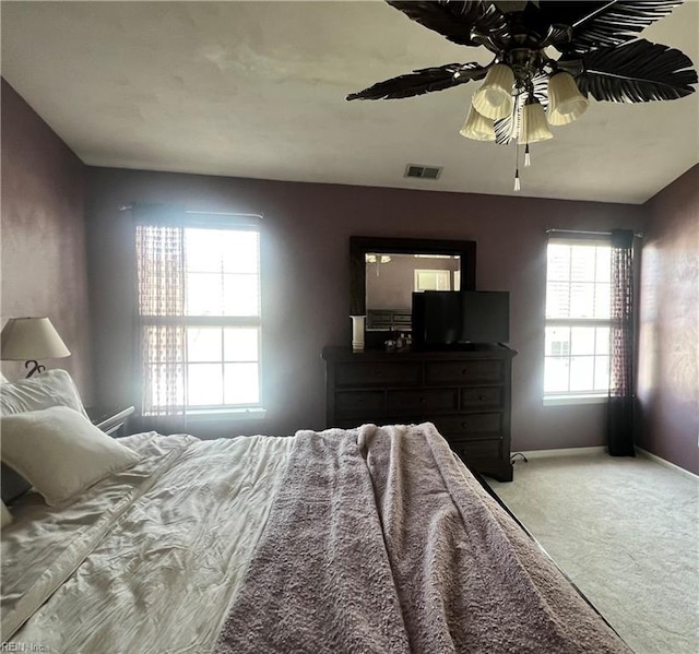 unfurnished bedroom featuring a ceiling fan, visible vents, light colored carpet, and baseboards