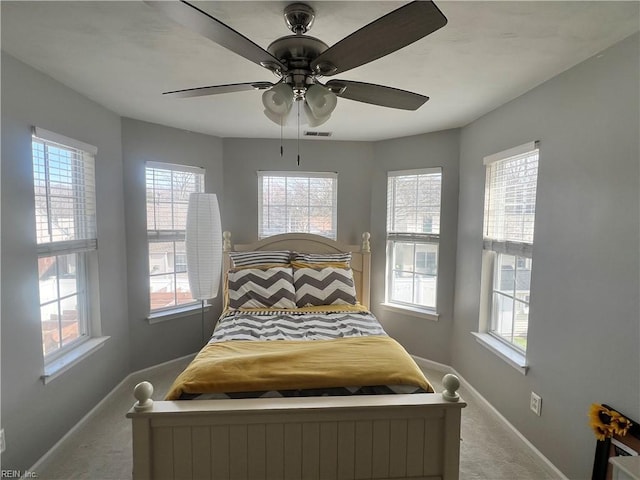 bedroom featuring visible vents, baseboards, a ceiling fan, and carpet flooring