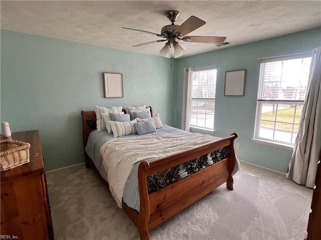 carpeted bedroom featuring visible vents, a ceiling fan, and baseboards