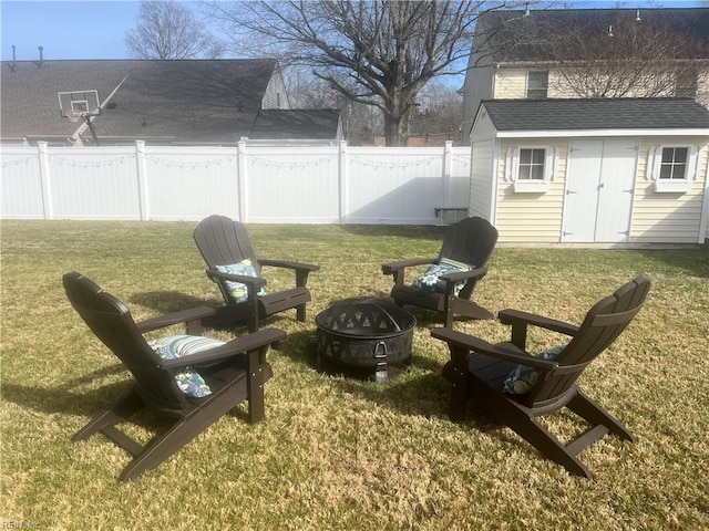 view of yard featuring fence, an outdoor structure, a storage shed, and an outdoor fire pit