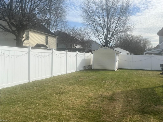 view of yard with a fenced backyard, an outbuilding, and a storage shed