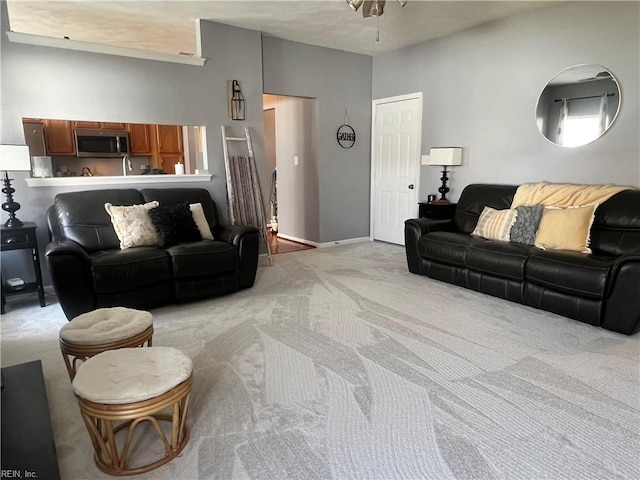 living area with baseboards and light carpet