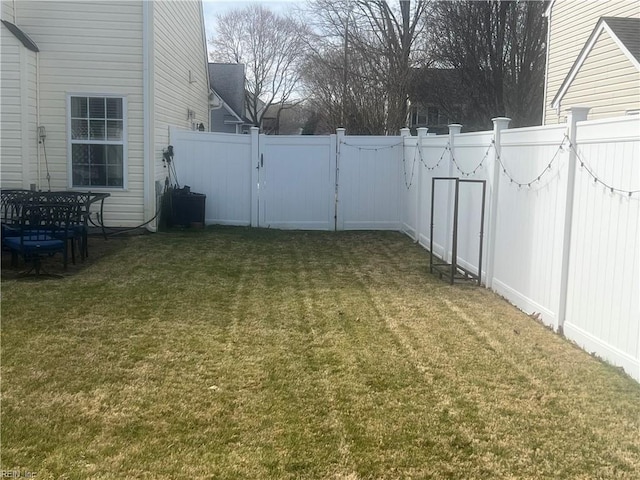 view of yard with a fenced backyard and a gate