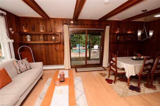 interior space featuring a notable chandelier, wooden walls, beam ceiling, and wood finished floors