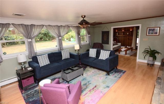 living room featuring baseboards, crown molding, visible vents, and wood finished floors