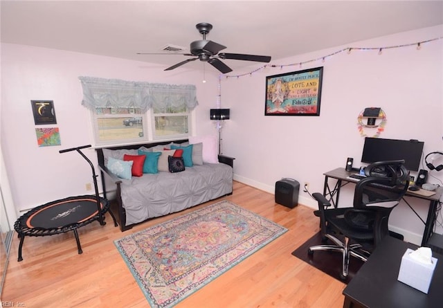 bedroom with ceiling fan, baseboards, and wood finished floors