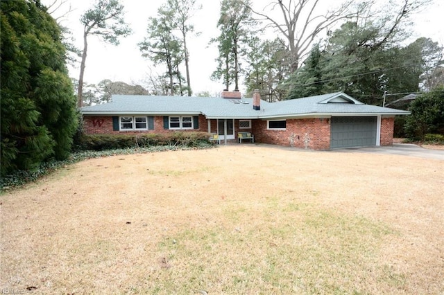 ranch-style home with driveway, a garage, brick siding, a chimney, and a front yard