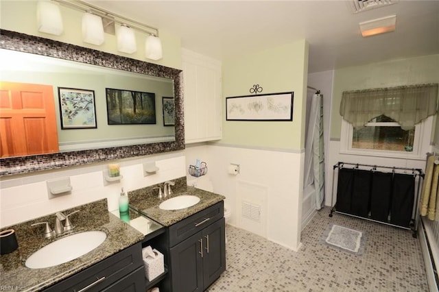 full bathroom featuring double vanity, shower / bath combo, visible vents, and a sink