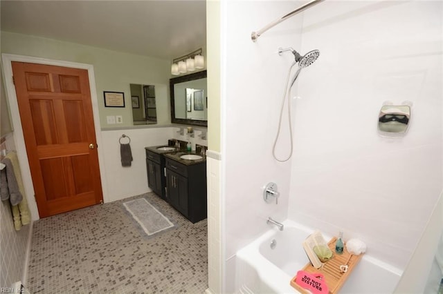 bathroom featuring a wainscoted wall, shower / tub combination, vanity, and tile walls