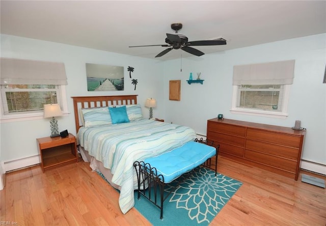 bedroom featuring light wood-type flooring, a baseboard radiator, and a ceiling fan