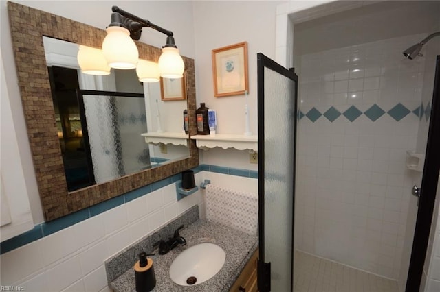 bathroom featuring tasteful backsplash, a stall shower, vanity, and tile walls