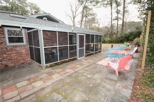 view of patio / terrace featuring outdoor dining space and a sunroom