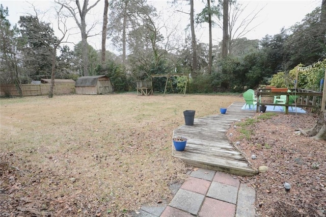 view of yard featuring an outbuilding, a storage unit, and fence