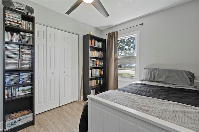 bedroom with light wood-style floors, a closet, and a ceiling fan