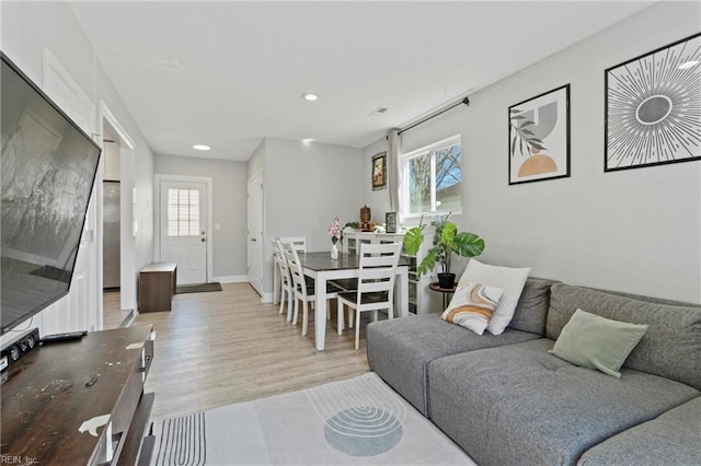 living room featuring recessed lighting, baseboards, and light wood finished floors