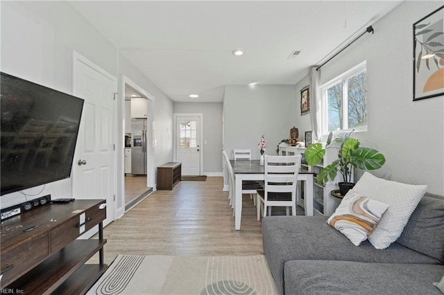 living room with light wood-style floors, baseboards, a wealth of natural light, and recessed lighting