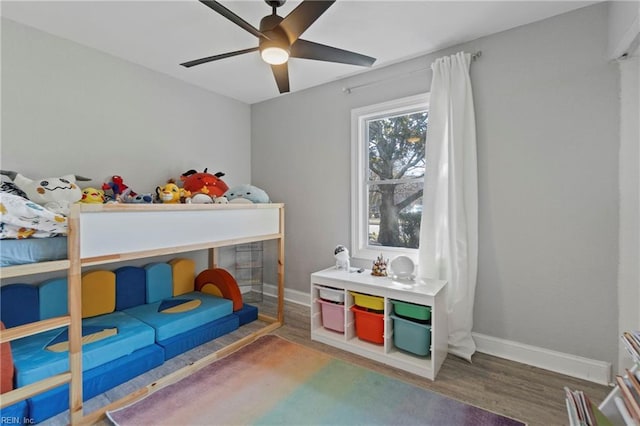 bedroom with wood finished floors, a ceiling fan, and baseboards