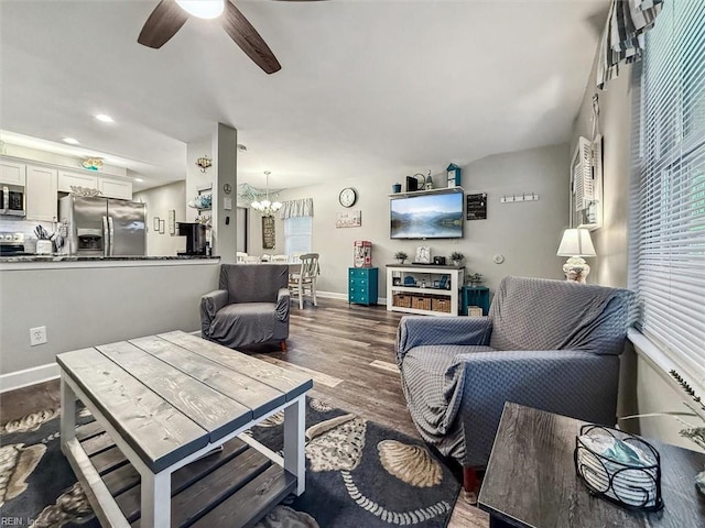 living area with dark wood-style floors, recessed lighting, ceiling fan with notable chandelier, and baseboards