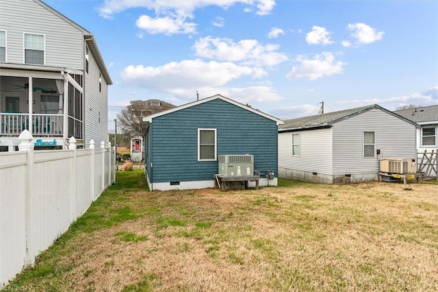 rear view of property with cooling unit, fence, a sunroom, a yard, and crawl space