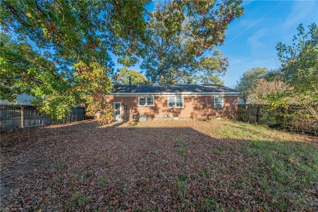 rear view of house featuring a fenced backyard and brick siding