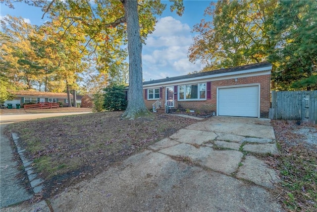 view of front facade with concrete driveway, brick siding, fence, and an attached garage