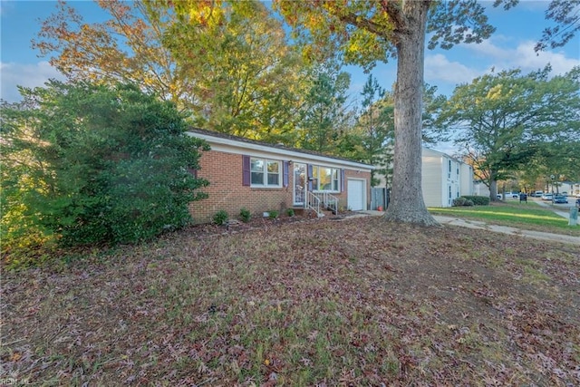 single story home featuring an attached garage and brick siding