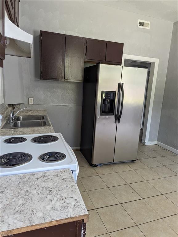 kitchen with dark brown cabinetry, a sink, visible vents, white range with electric stovetop, and stainless steel fridge with ice dispenser