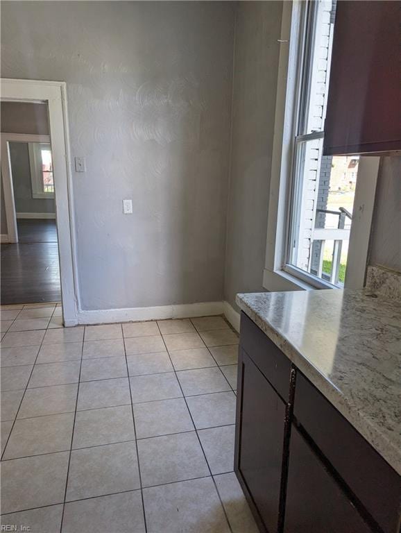 interior space with light tile patterned floors and baseboards