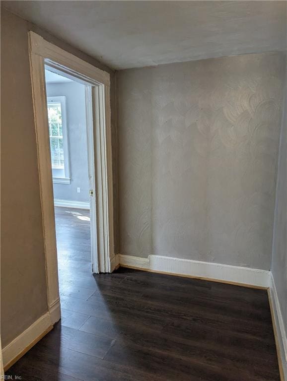 unfurnished room featuring dark wood-style floors and baseboards