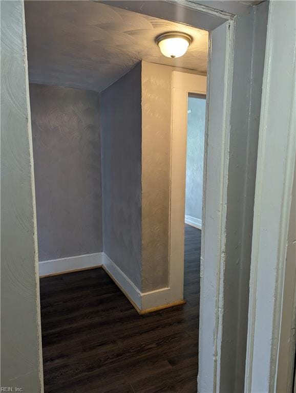 interior space with baseboards and dark wood-style flooring