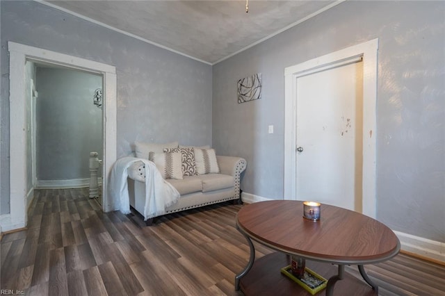 living area featuring ornamental molding, wood finished floors, and baseboards