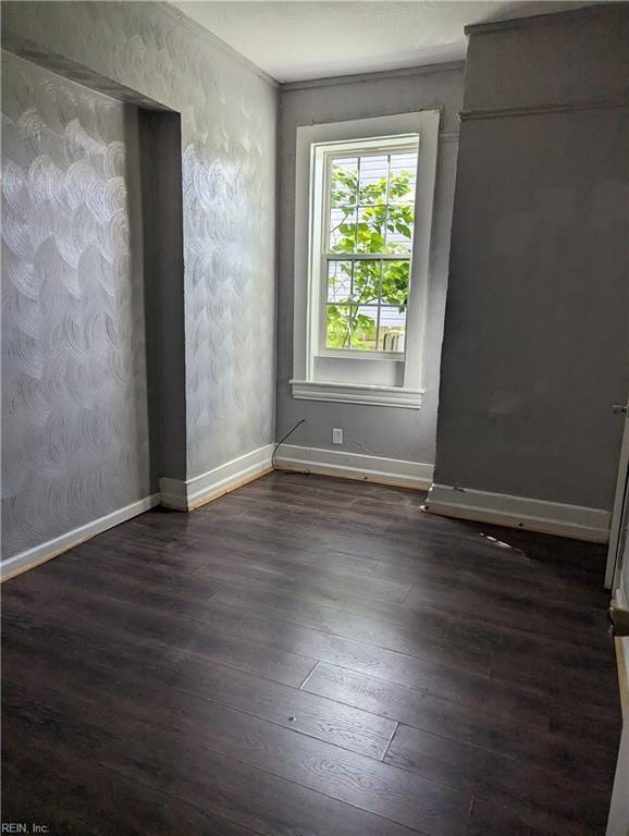 empty room with dark wood finished floors and baseboards