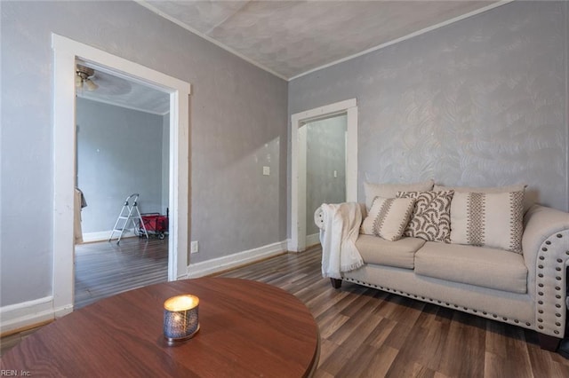 living room with baseboards, wood finished floors, and ornamental molding