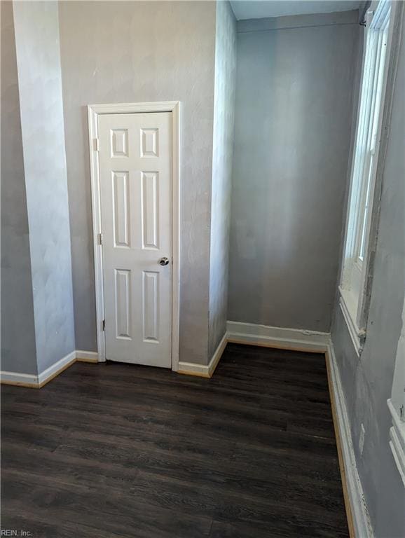 interior space with dark wood-style flooring and baseboards