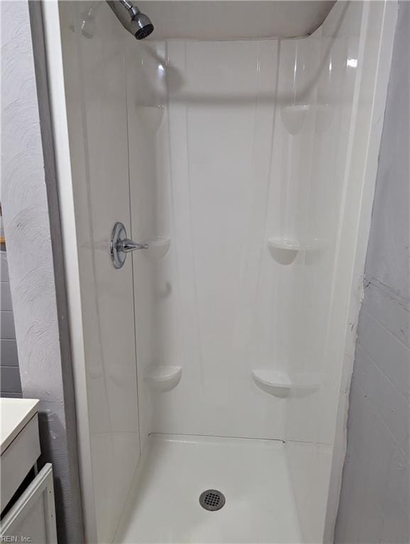 full bath with a stall shower and vanity