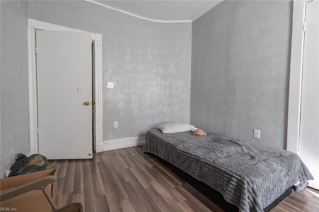 bedroom featuring wood finished floors and baseboards