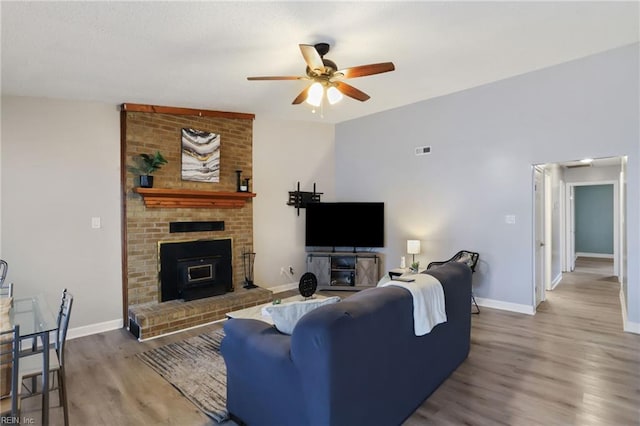 living area with a ceiling fan, baseboards, and wood finished floors