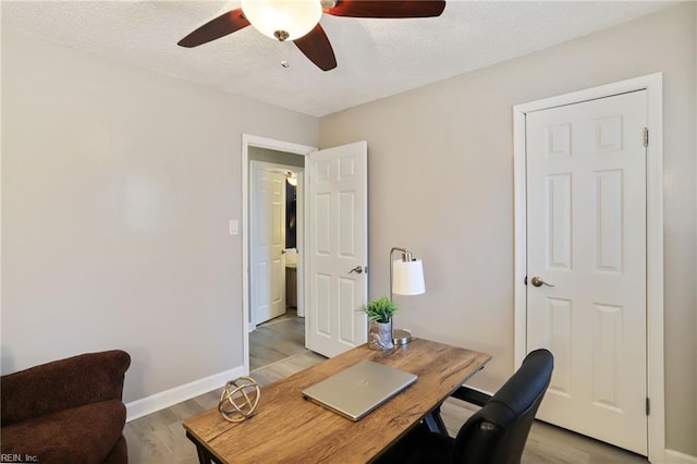 office with a textured ceiling, ceiling fan, light wood-style flooring, and baseboards