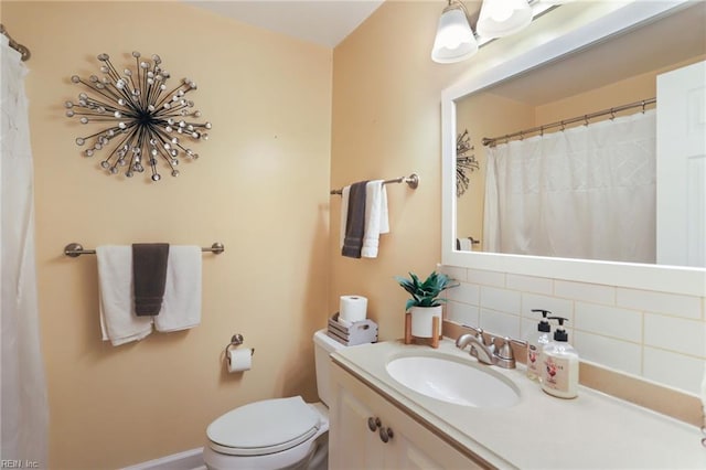 full bath featuring toilet, backsplash, and vanity