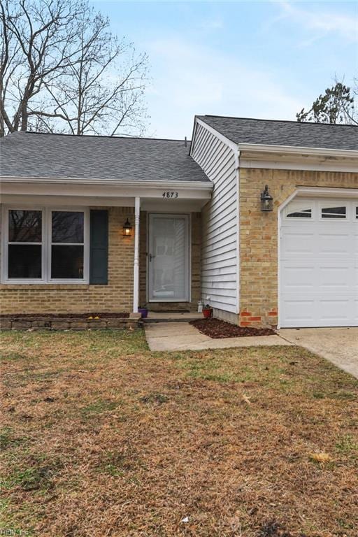 view of front of house with a garage, a front yard, brick siding, and a shingled roof