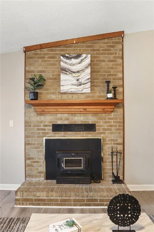 interior details with visible vents, a textured ceiling, baseboards, and wood finished floors