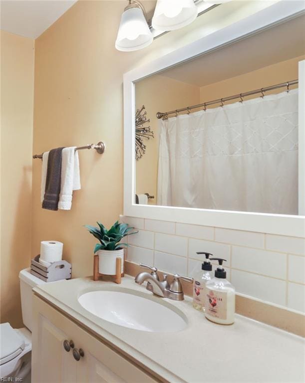 full bathroom featuring toilet, tasteful backsplash, and vanity