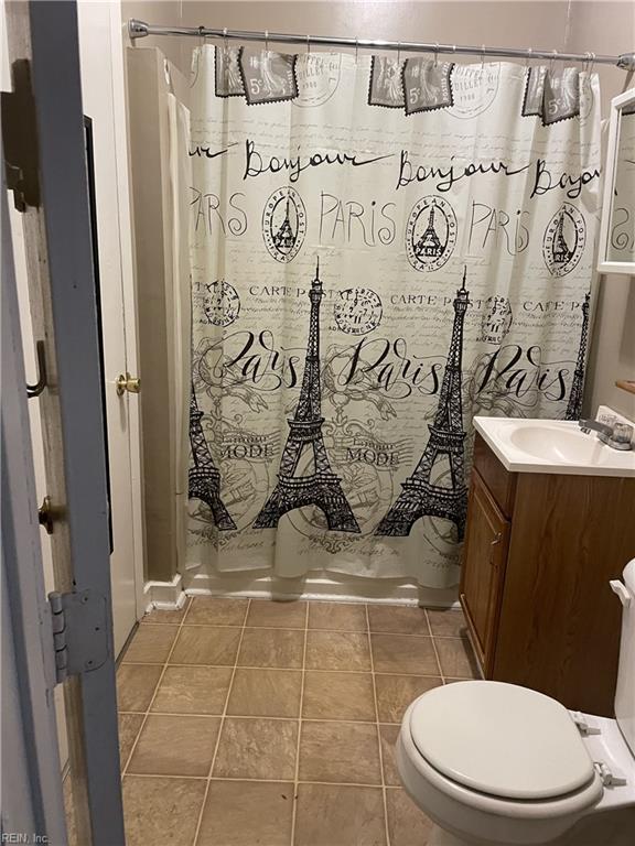 full bath featuring a shower with curtain, tile patterned floors, toilet, and vanity