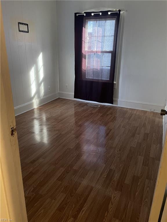 empty room with baseboards and wood finished floors